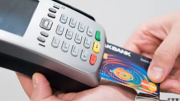 Maquininha processando pagamento de cartão de crédito plástico