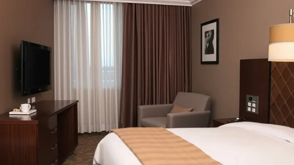 Lobby elegante de hotel com iluminação quente, sofás modernos e balcão de recepção ao fundo