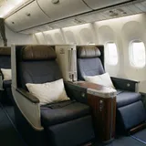 Cabine de classe executiva de avião de fuselagem larga com poltronas em configuração privativa