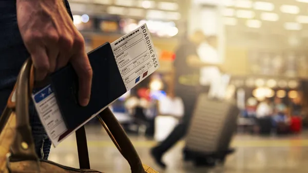 Cartão de embarque e passaporte sobre mesa de aeroporto, simbolizando programa de fidelidade aéreo
