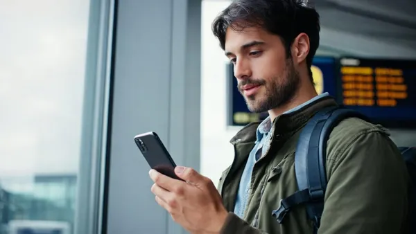 Painel de embarques de aeroporto com viajantes desfocados em primeiro plano