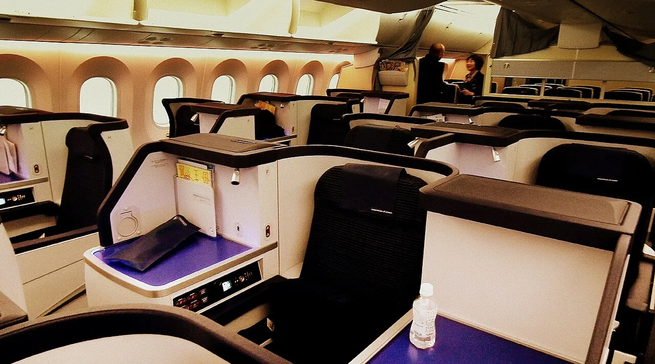 Cabine de classe executiva em aeronave Boeing 787 com poltronas reclináveis e iluminação ambiente